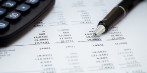 Pen and calculator on top of financial report